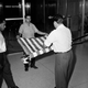 FILE - This Jan. 7, 1961 file photo shows unidentified U.S. embassy employees rolling up a U.S. flag as the embassy transfers American affairs to the Swiss government, in Havana, Cuba. The U.S. Interests Section is poised to be transformed into a full embassy, which would include such symbolic measures such as raising the American flag on the Malecon, after the U.S. and Cuba announced on Dec. 17, 2014 they are re-establishing full diplomatic relations.